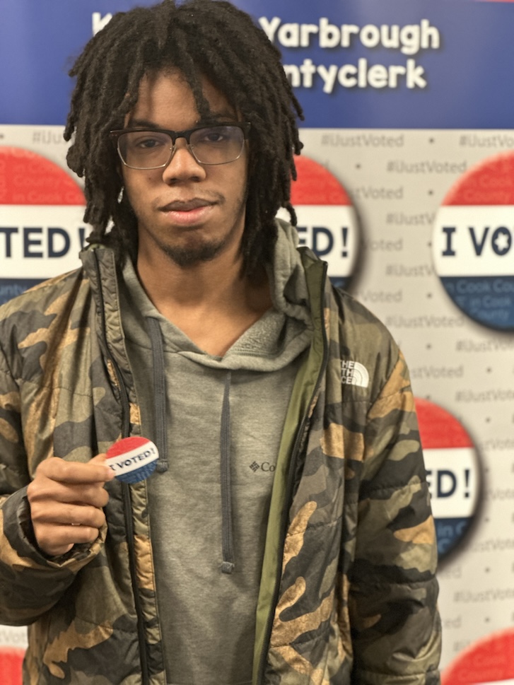 Student holding I VOTED sticker